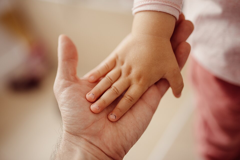Small cute hand of a child in father's palm.jpg